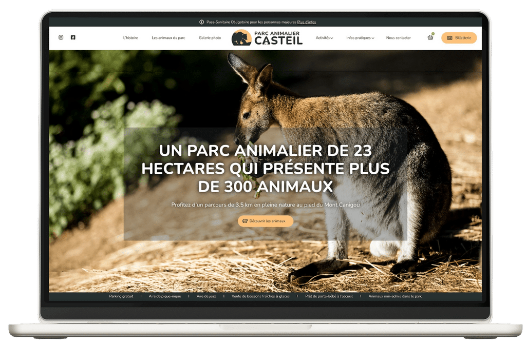 Laptop affichant le site du Parc Animalier Casteil, kangourou sur paille, menu visible, texte en français.